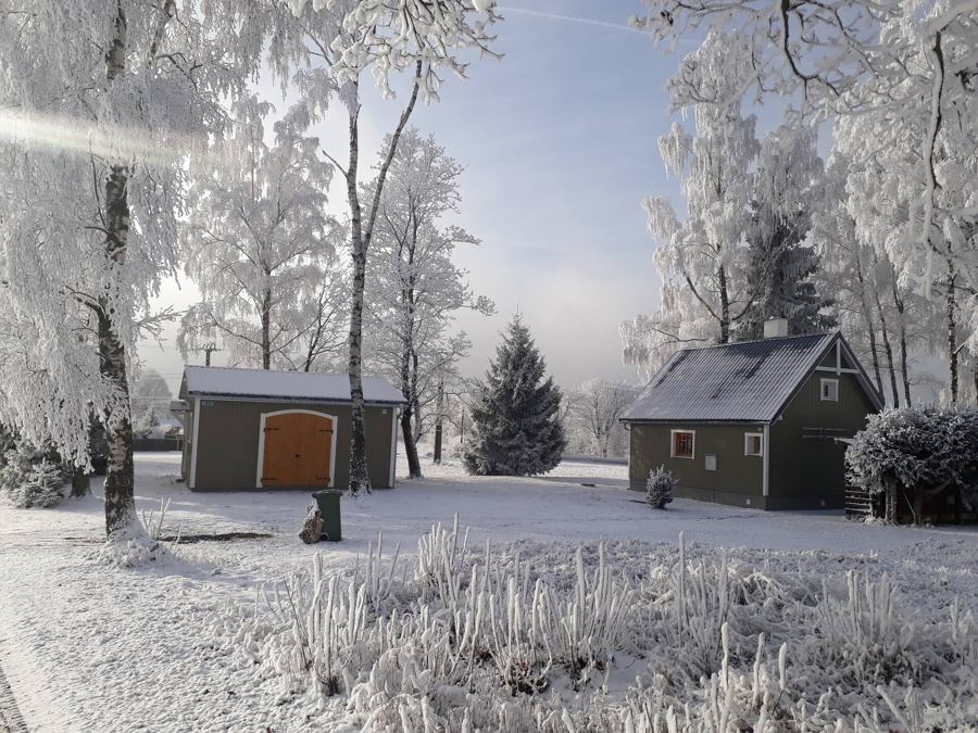 Chata a dřevník v zimě, stromy pokryté jinovatkou